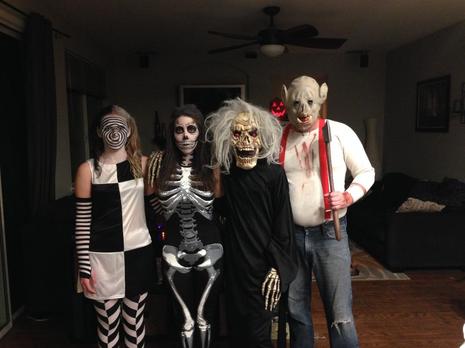 People posing in a house wearing Halloween costumes